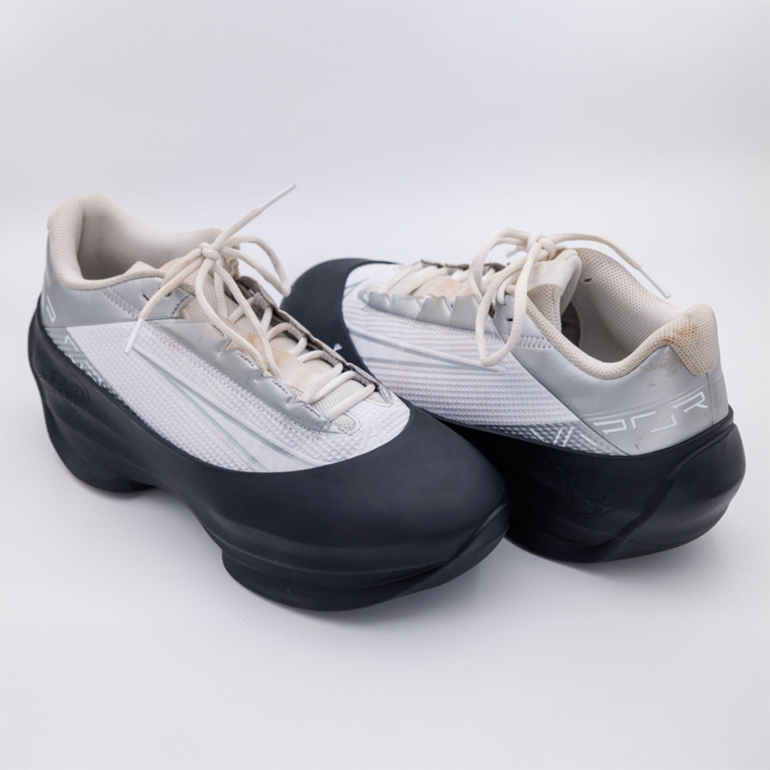 Pair of white and black shoes on a light gray background