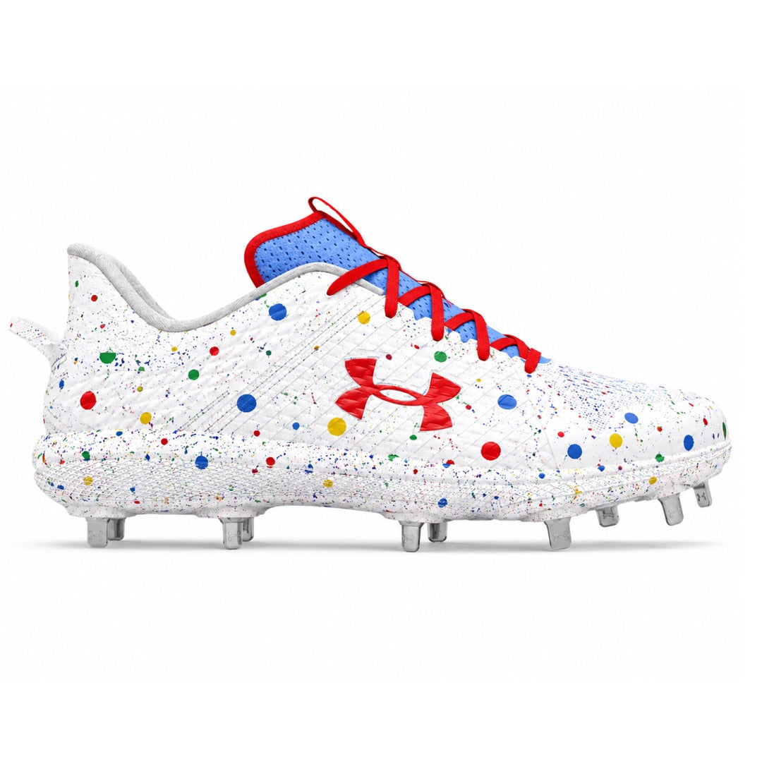 Under Armour Yard MT low-top baseball cleats in white with multicolor red, blue, yellow and green confetti dot splatter print, red Under Armour logo, red laces, blue collar, and metal spikes on white background by Stadium Custom Kicks.