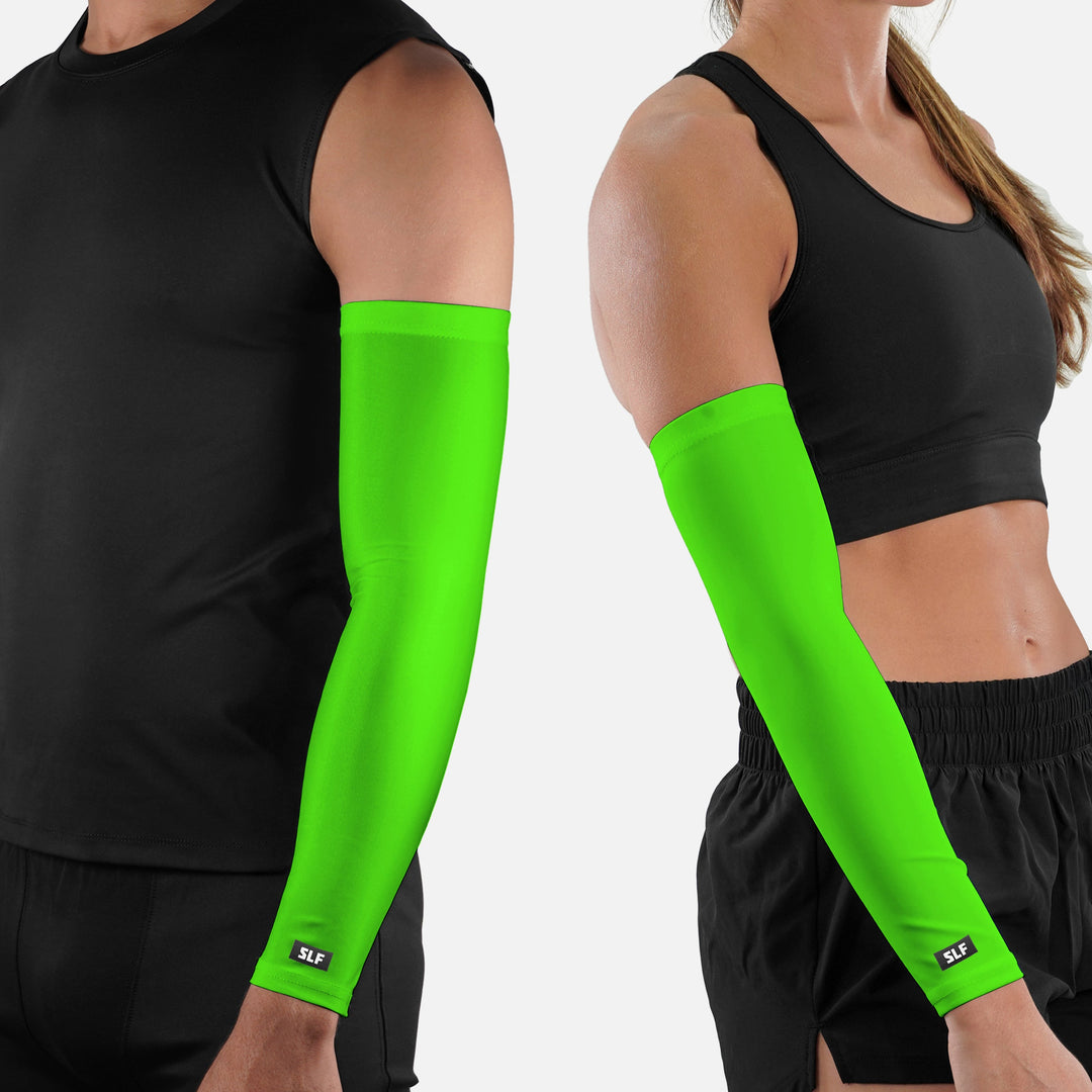Two people wearing bright green arm sleeves on a white background