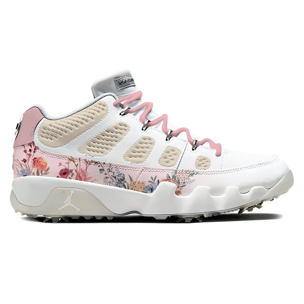 Air Jordan 9 Retro Low golf shoes in white and pink with floral botanical print along the midsole panel, pink laces, and metal golf spikes on white background by Stadium Custom Kicks