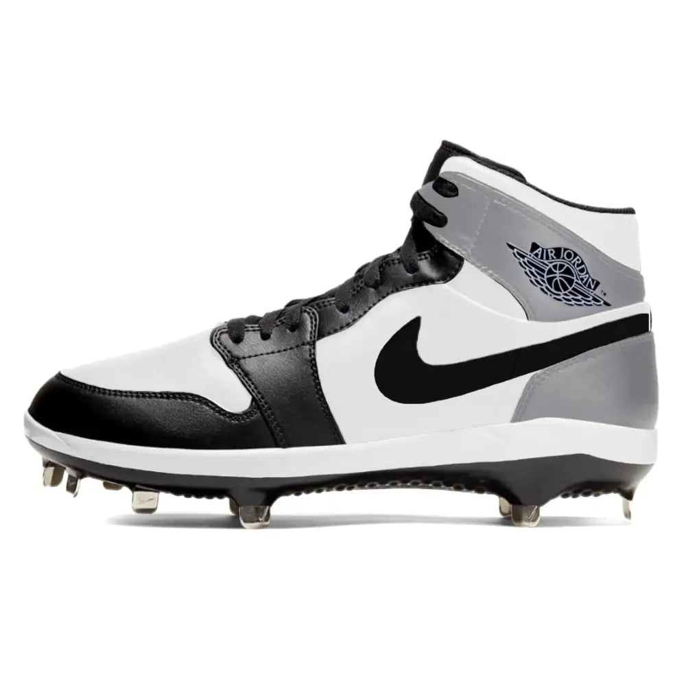 Black, white, and gray Jordan 1 Retro Barons baseball cleats on a white background