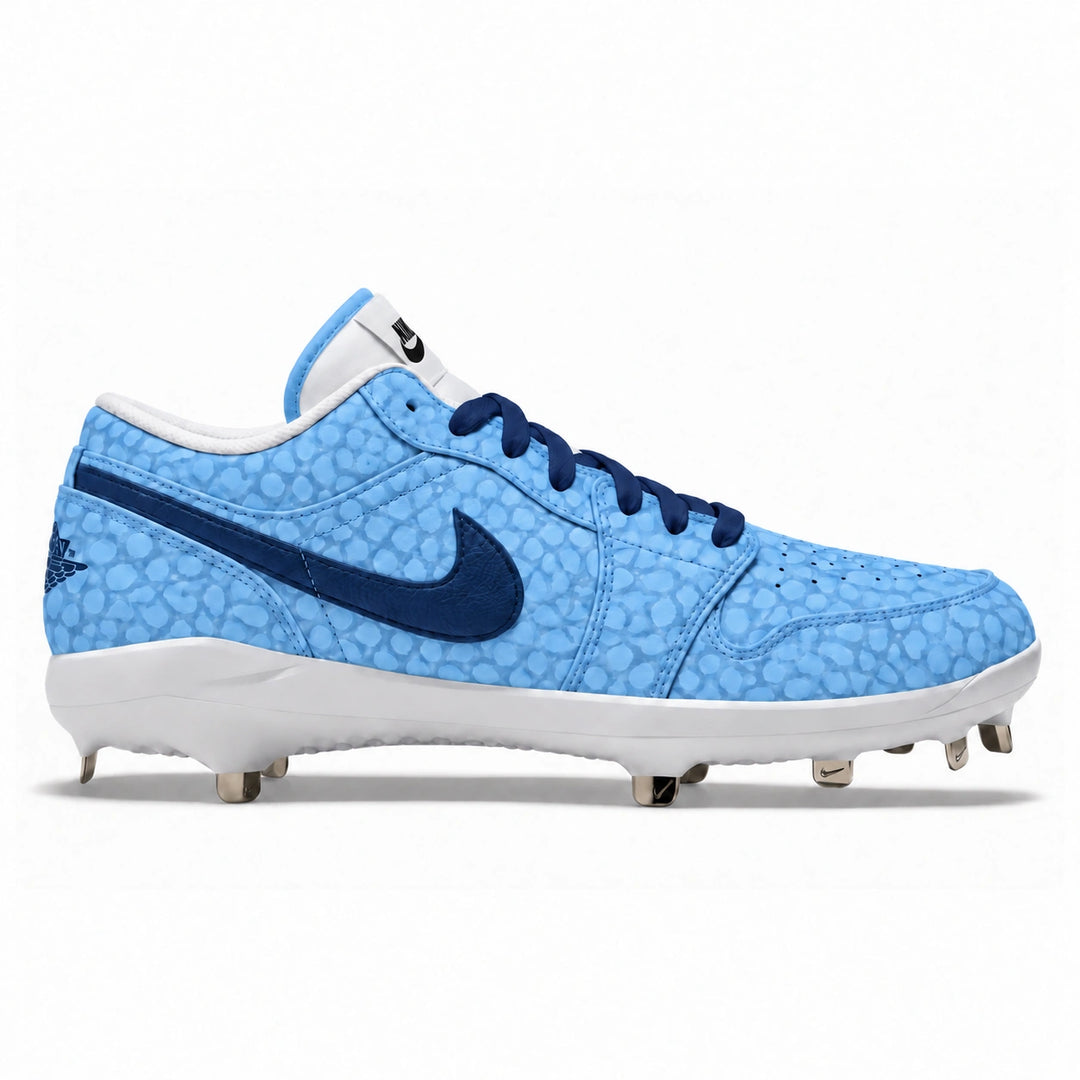 A Nike baseball cleat in light blue with a textured pattern, navy blue swoosh and laces, and a white midsole with metal studs, shown from the side on a white background.
