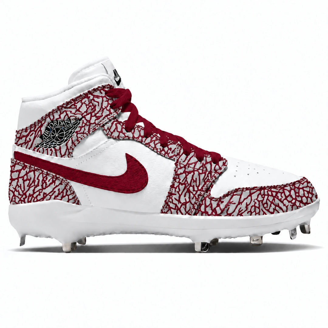 A high-top Nike baseball cleat featuring a white leather base with a crimson cracked-cement pattern on the overlays and toe box, a maroon Swoosh, and a black and white Jordan Wings logo on the ankle.