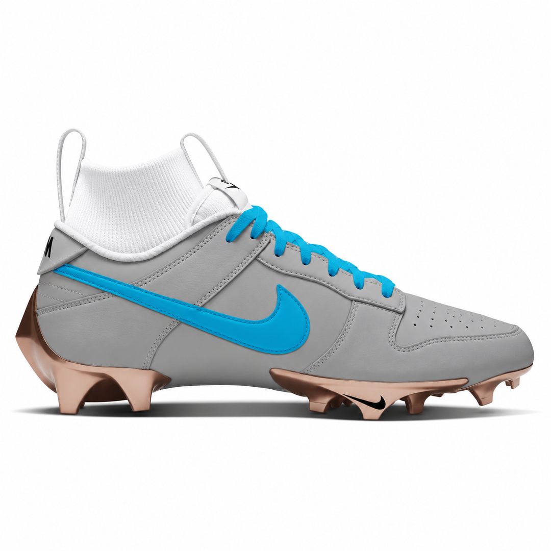 Carolina blue and gray Nike football cleat featuring a matte blue Swoosh and laces, gray upper, white tongue and sockliner, and metallic bronze sole.