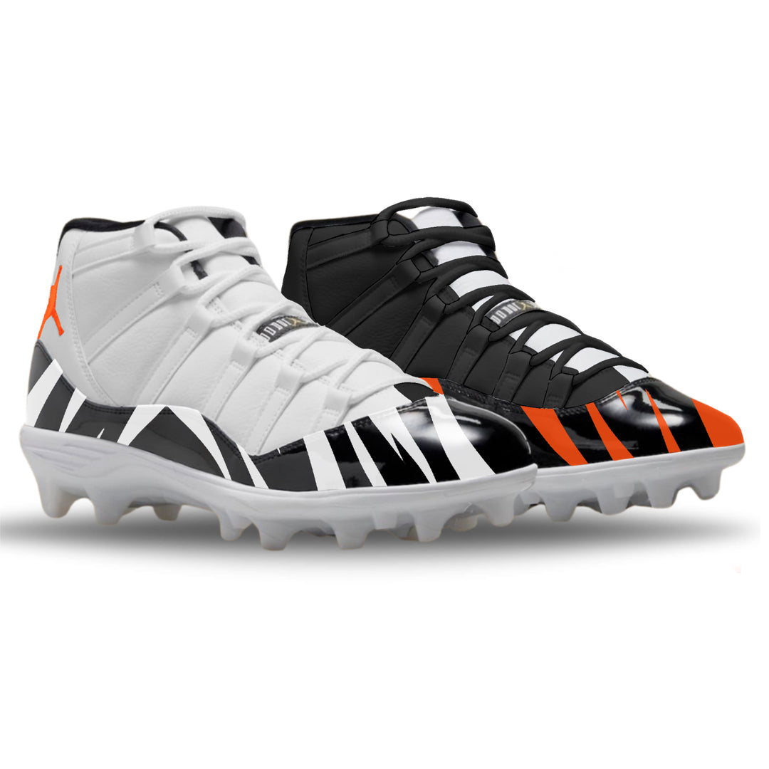Pair of white and black cleats with orange accents on a white background