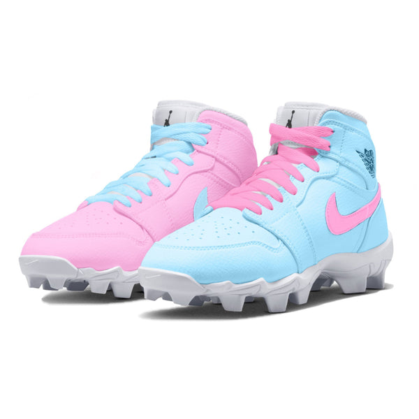 light blue and pink mismatched mid top youth cleats in a side view.