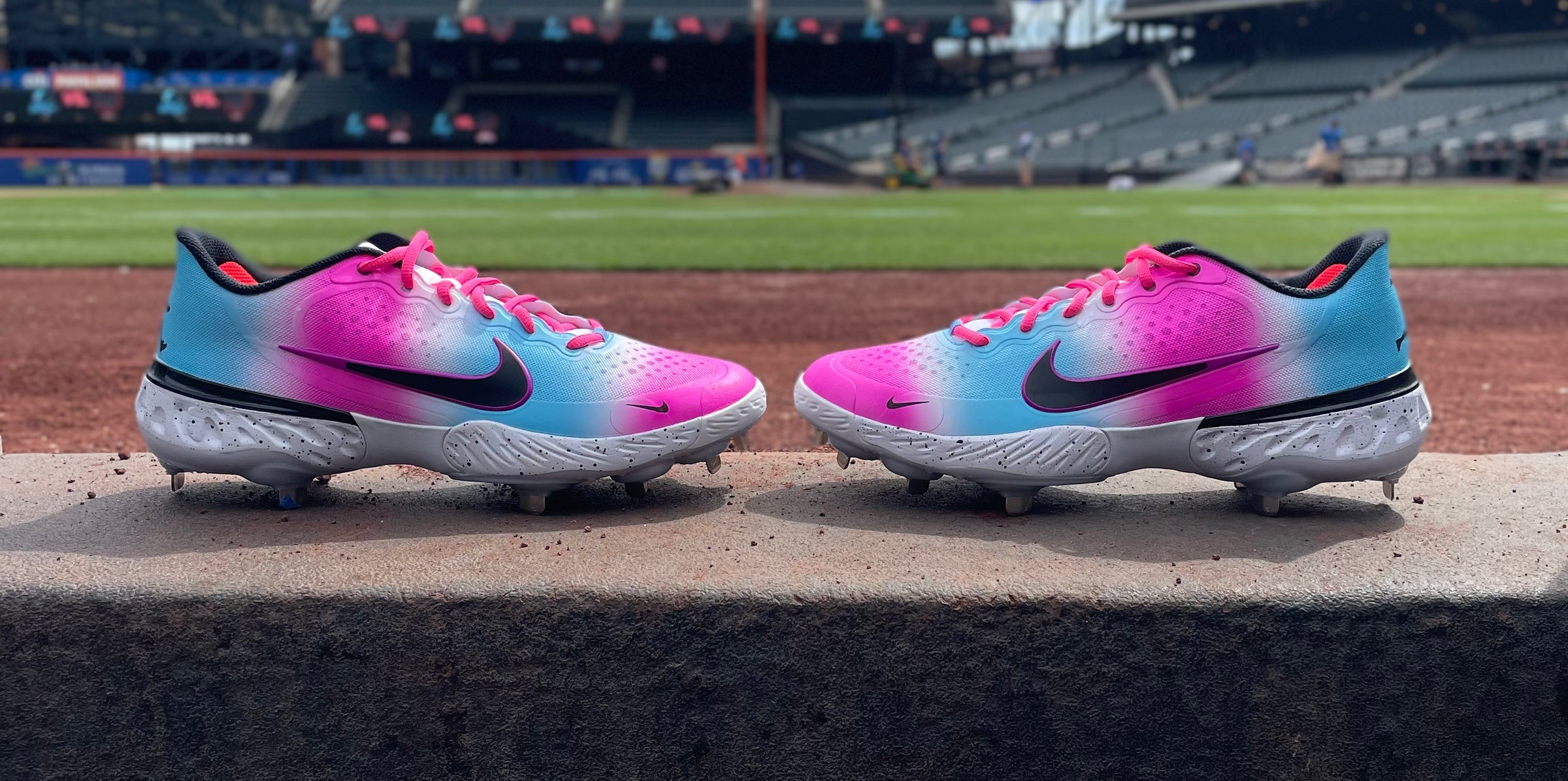 Pair of colorful baseball cleats on a ledge with Citi Field in the background