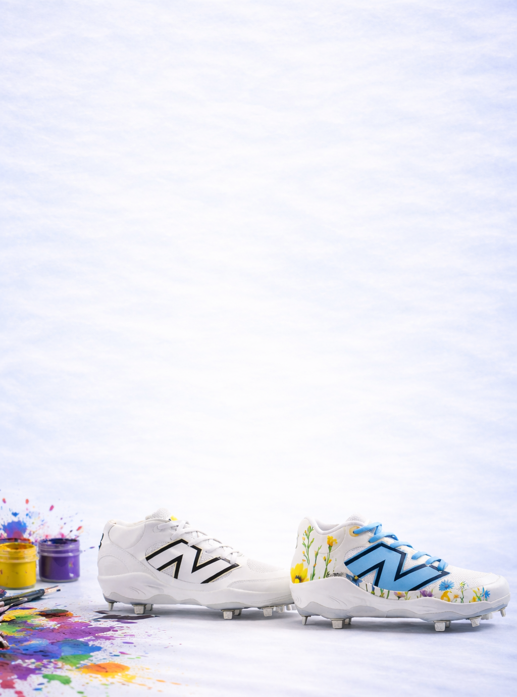 Pair of white baseball cleats with colorful designs on a light blue background