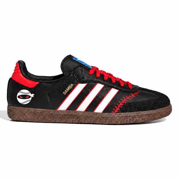 A leather low-top sneaker inspired by the Adidas Gazelle, featuring red laces, red heel tab, white three-stripes with red borders, a red baseball-stitch pattern on the side, a cork-look midsole, and a white circular patch with a red baseball logo.
