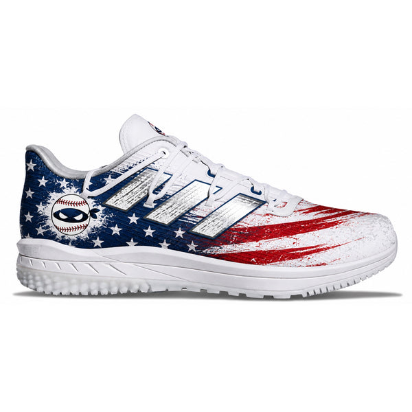 A white athletic cleat featuring a distressed American flag design with blue and red paint strokes and white stars, shown from the side on a white background.