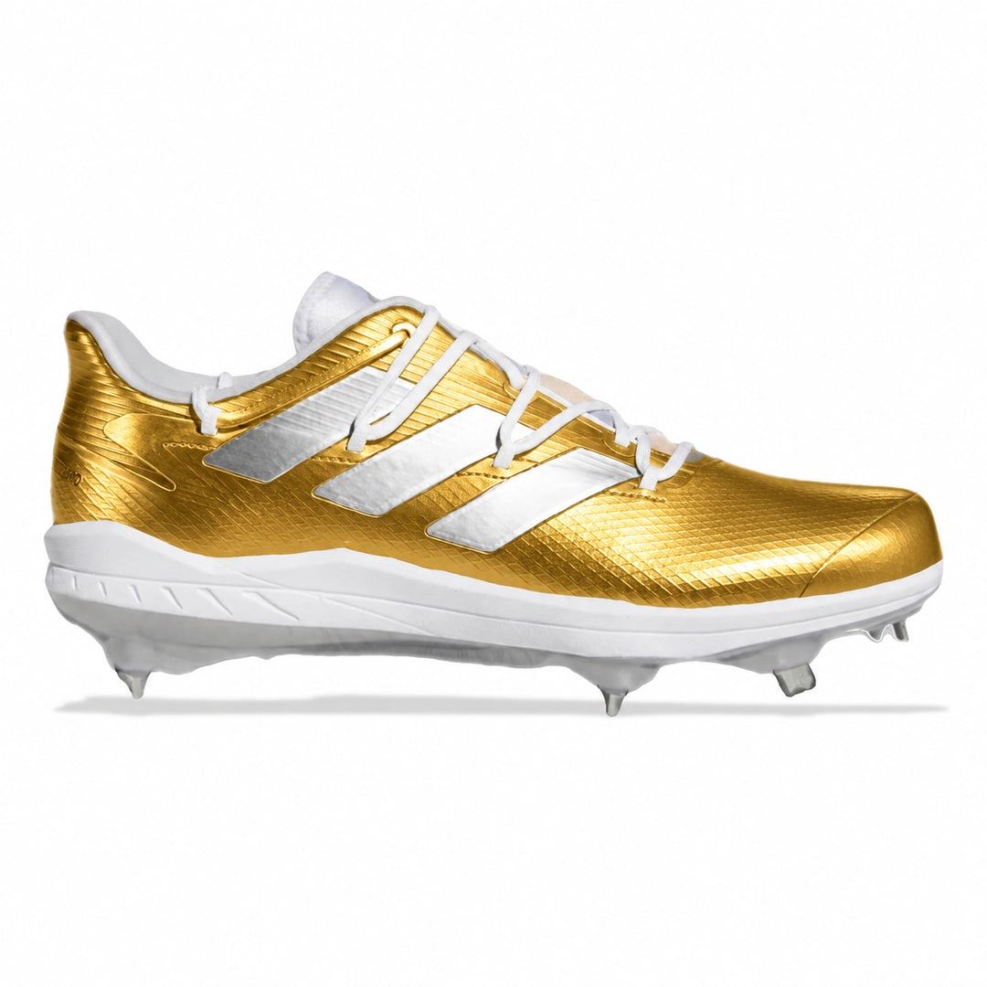 A single baseball cleat in metallic gold and white, shown in a side profile on a clean white background. The shoe features a textured gold upper with three white stripes, white laces, and a white sole with metal studs.