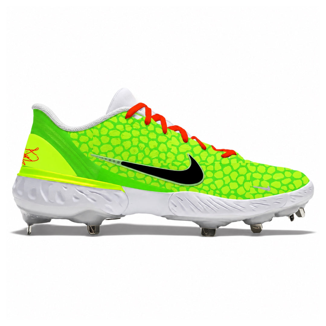A Nike baseball cleat featuring a neon green and lime green patterned upper, a black Nike Swoosh, bright red laces, and a white sole with metal studs, shown against a plain white background.