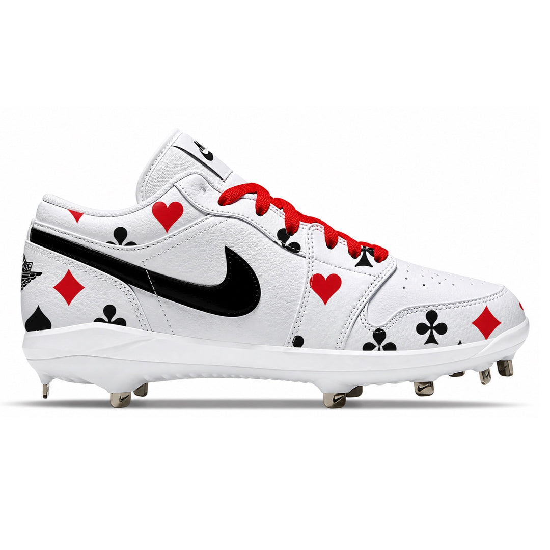 White Nike baseball cleats with red and black playing card suit graphics, glossy black Swoosh, red laces, and black molded studs, shown in side profile.