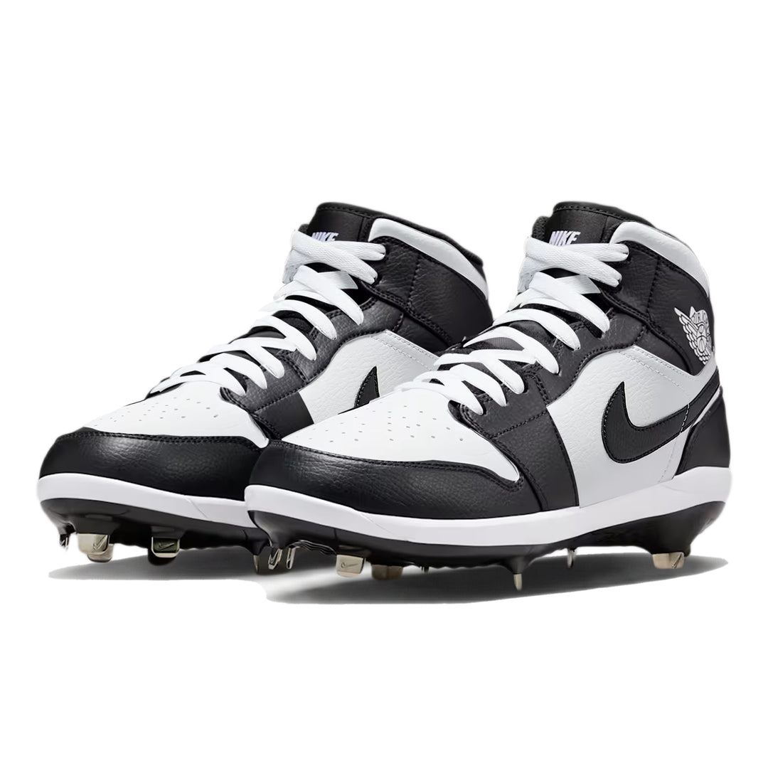 Angled view of custom Jordan 1 Retro Panda mid-top baseball cleats with metal spikes, hand-painted in black and white.