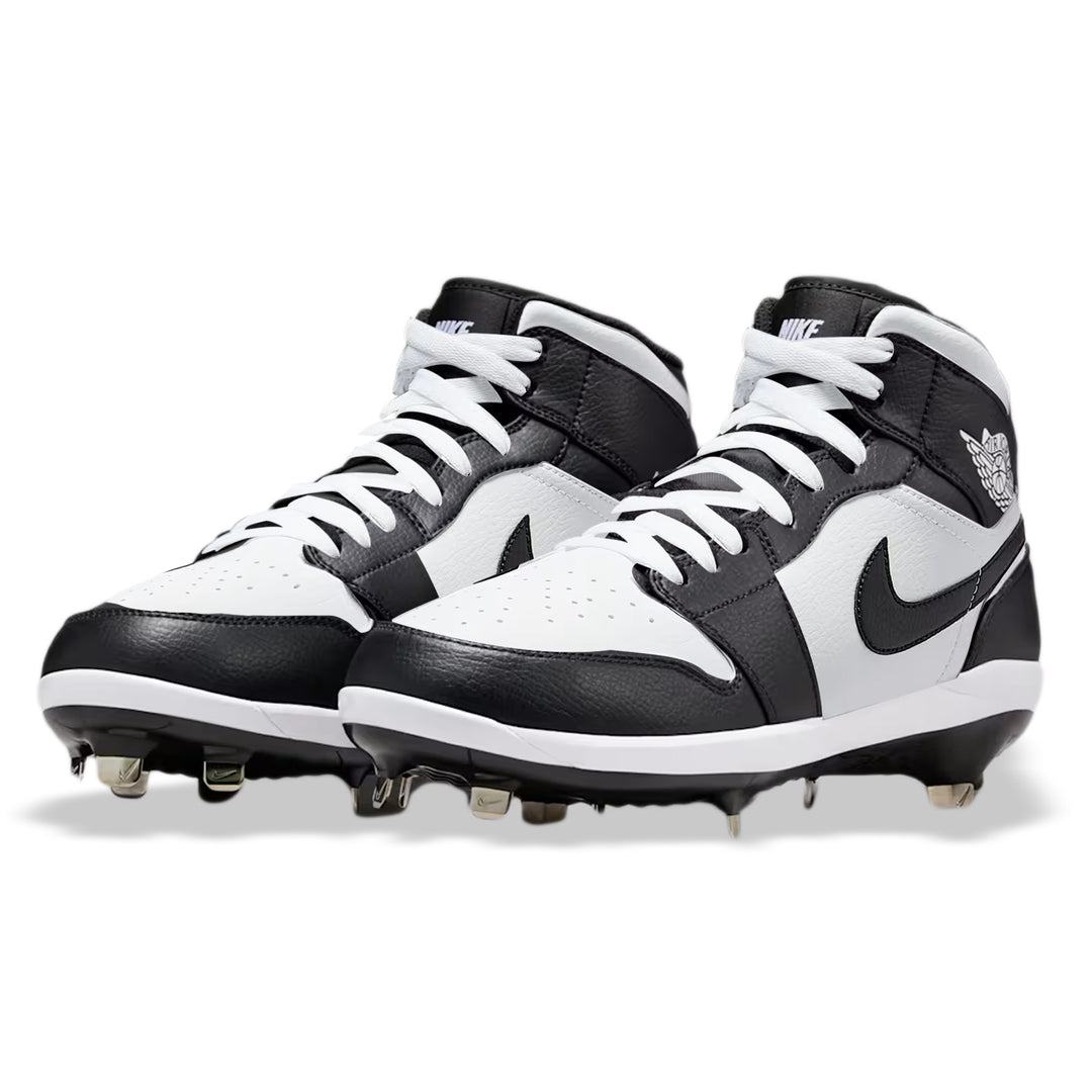Angled view of custom Jordan 1 Retro Panda mid-top baseball cleats with metal spikes, hand-painted in black and white.