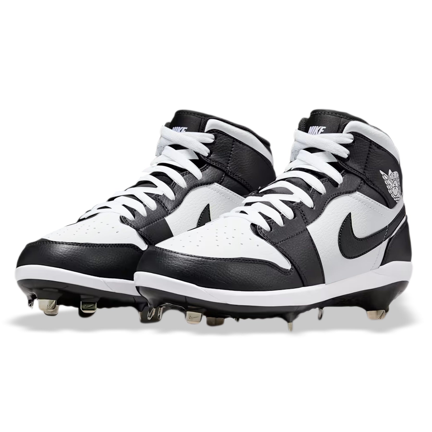 Angled view of custom Jordan 1 Retro Panda mid-top baseball cleats with metal spikes, hand-painted in black and white.