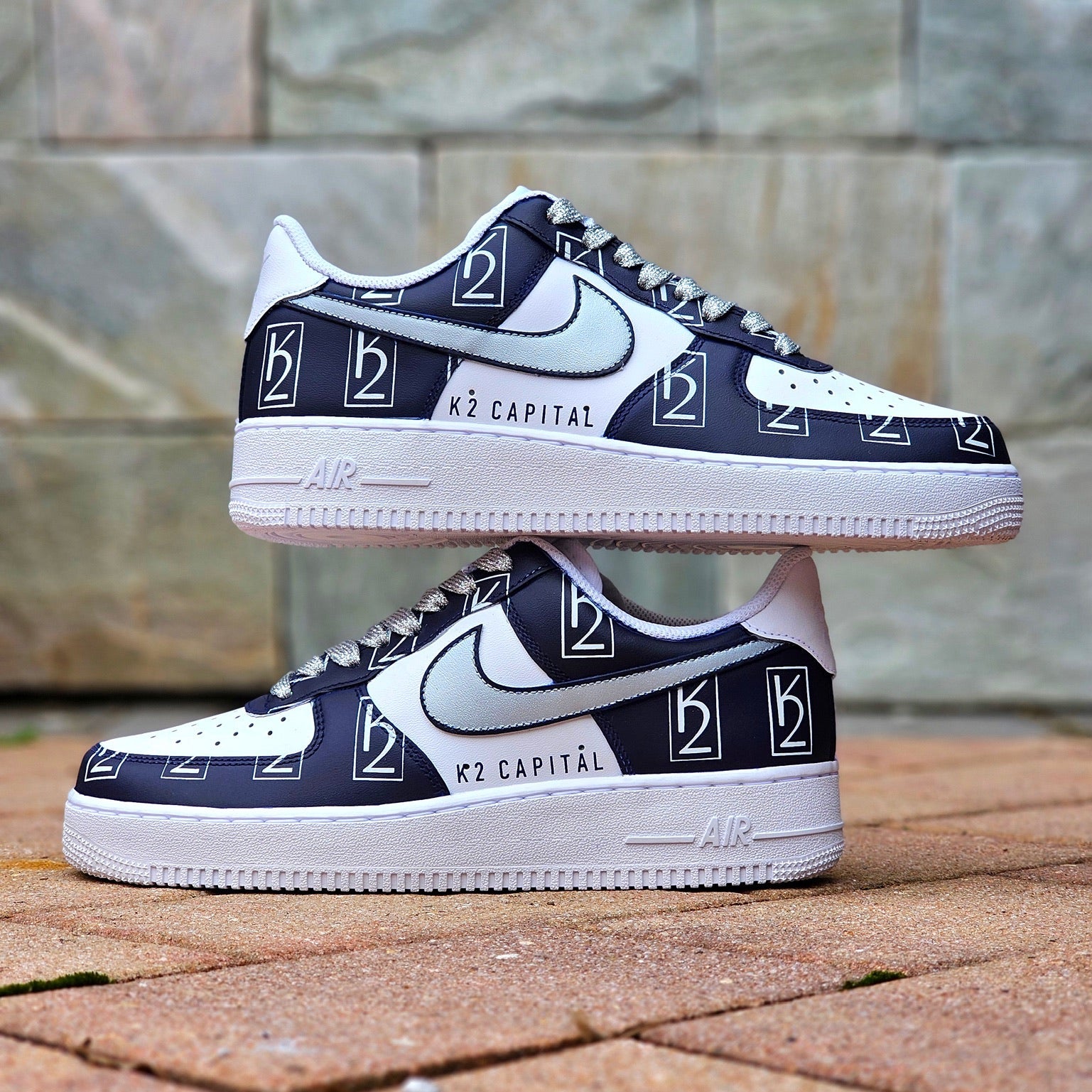 Navy and white sneaker with branding on a stone pavement background