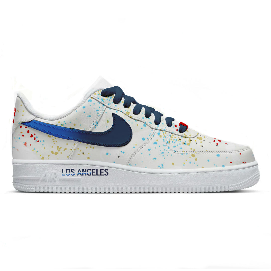 White sneaker with blue swoosh logo and colorful speckles on a white background