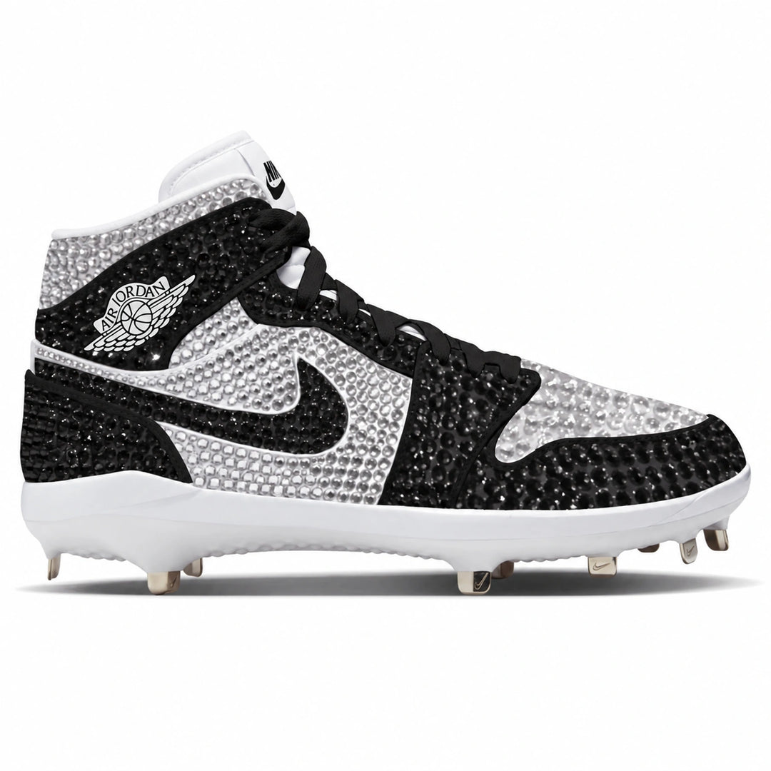 A high-top Nike baseball cleat embellished with rhinestones, featuring a black and white crystal-embellished upper, a white midsole, and silver cleats on a white background.