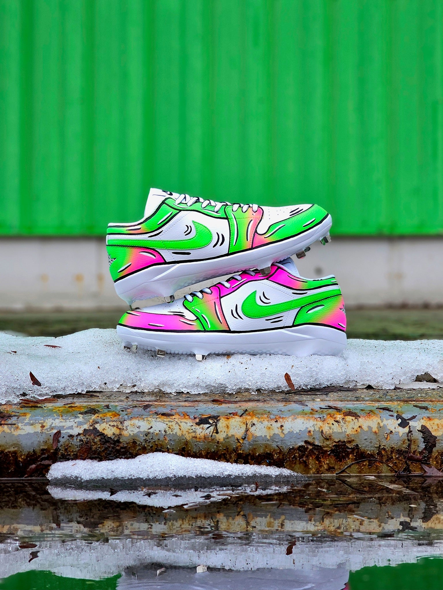 Colorful baseball cleats with a abstract design on a green and rusty metal surface