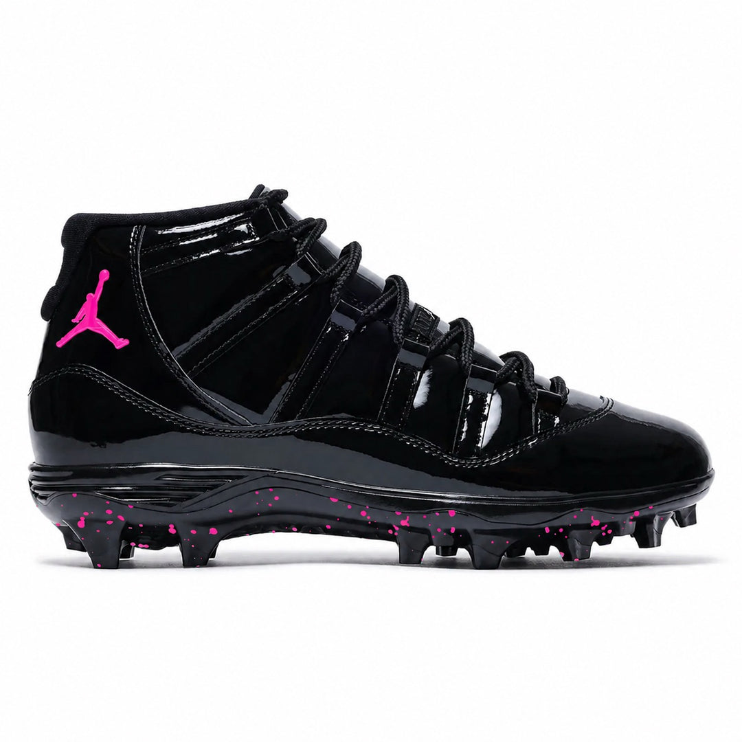 Pink Voltage Jordan 11 Retro TD football cleats featuring a glossy black patent leather upper, black ballistic mesh side panels, hot pink embroidered Jumpman logo on the ankle, black lace-up closure, and a black midsole with hot pink speckled molded traction outsole by Stadium Custom Kicks.