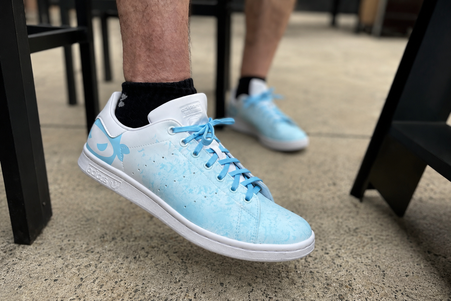 Man wearing pitching ninja white and carolina blue sneakers.