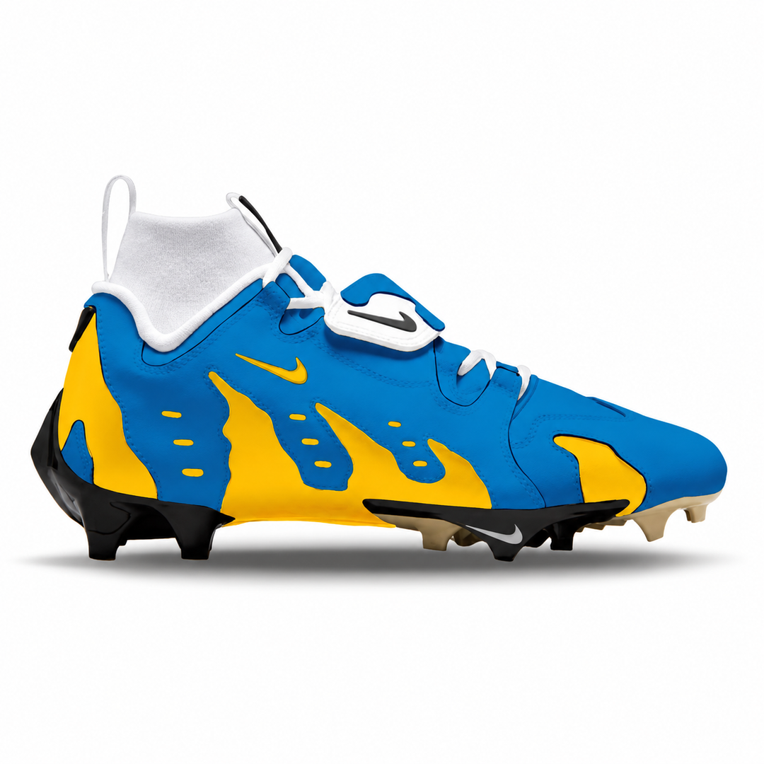 A Nike football cleat in royal blue and yellow with a flame pattern, white collar and laces, and black and beige studs, shown from a side profile on a white background.