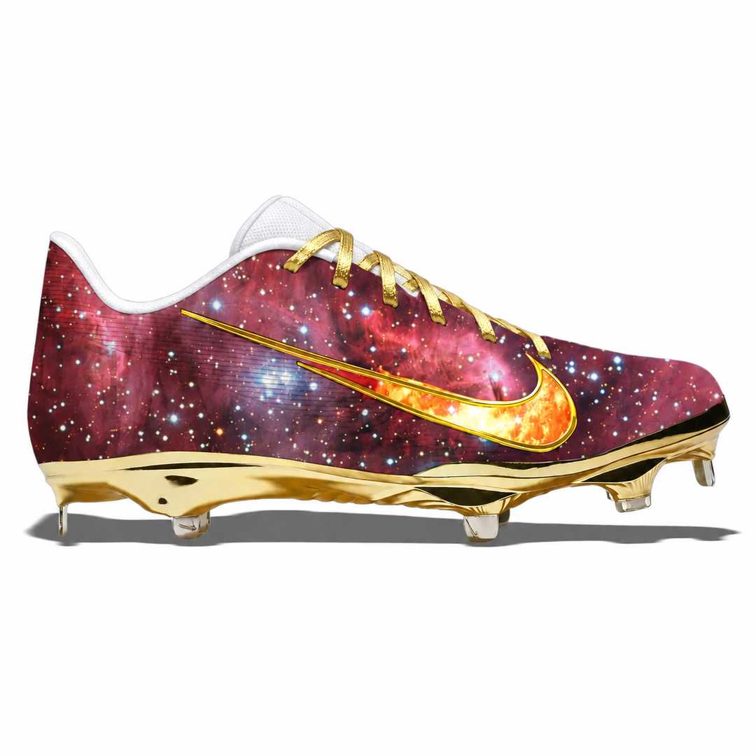 A single Nike baseball cleat with a metallic gold sole and a red and orange galaxy print upper, shown from the side on a white background.