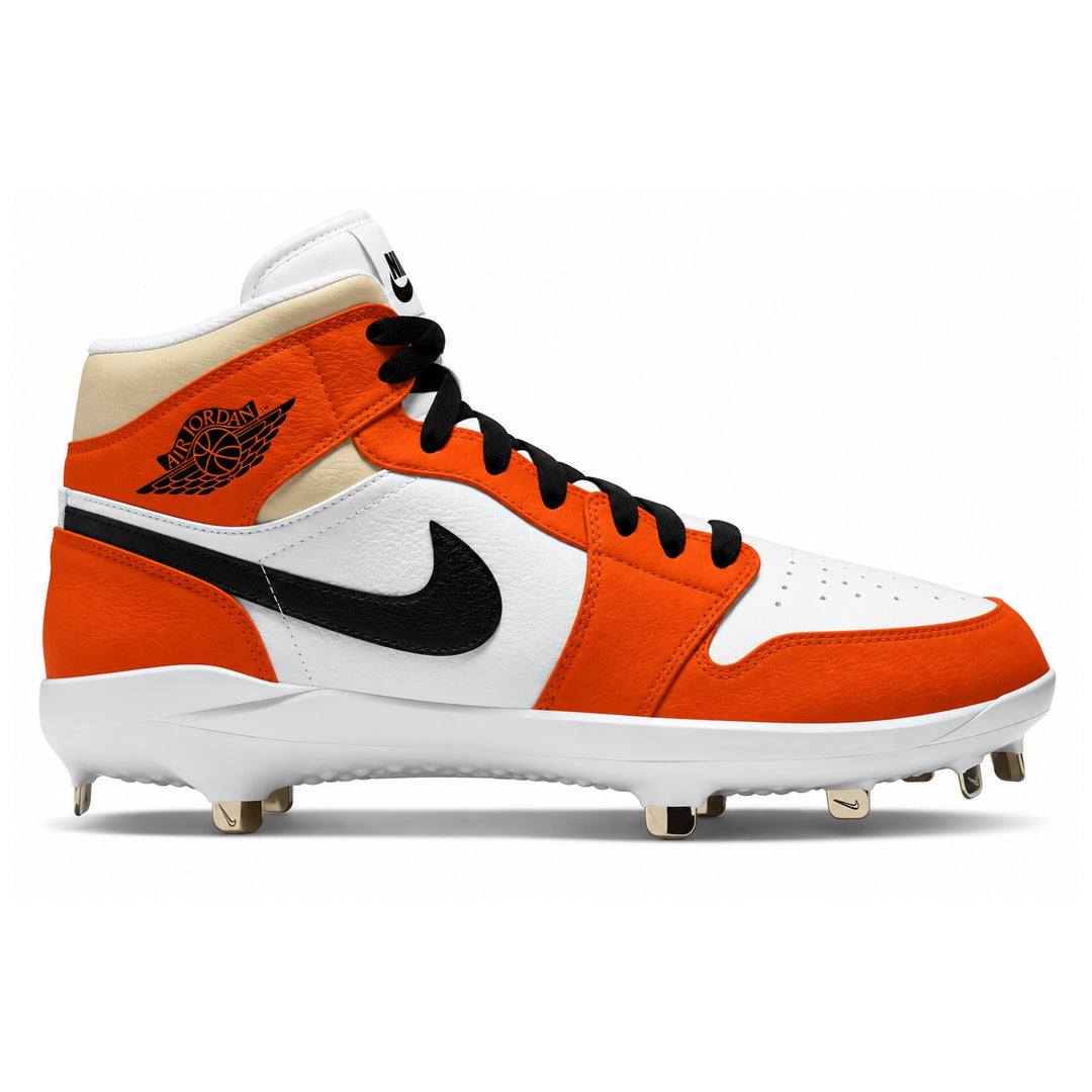 A Nike high-top baseball cleat in orange, white, and black, featuring the Air Jordan Wings logo on the heel, a black Nike Swoosh, and gold-colored metal cleats on a white sole, shown against a plain white background.