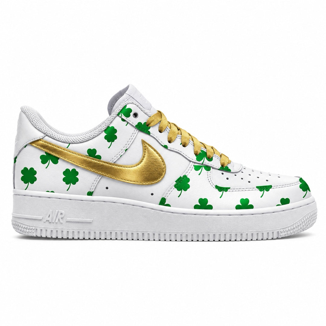 A white Nike Air Force 1 sneaker decorated with green shamrock patterns and a metallic gold Swoosh and laces, shown from a side profile on a white background.
