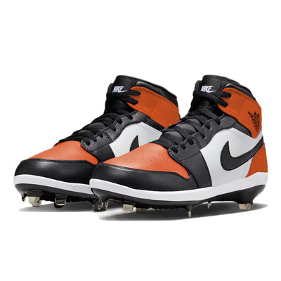 Angled view of Jordan 1 Retro baseball cleats in the Shattered Backboard color way, showcasing orange and black leather panels, white midsole, metal spikes, and hand-painted custom design by Stadium Custom Kicks.