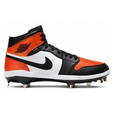 A high-top baseball cleat from the Nike Jordan line, featuring a black leather and white leather upper with vibrant orange overlays on the toe, heel, and collar. The shoe has a black Swoosh on the side, a black Jumpman logo on the heel, black laces, and metal studs on the sole.