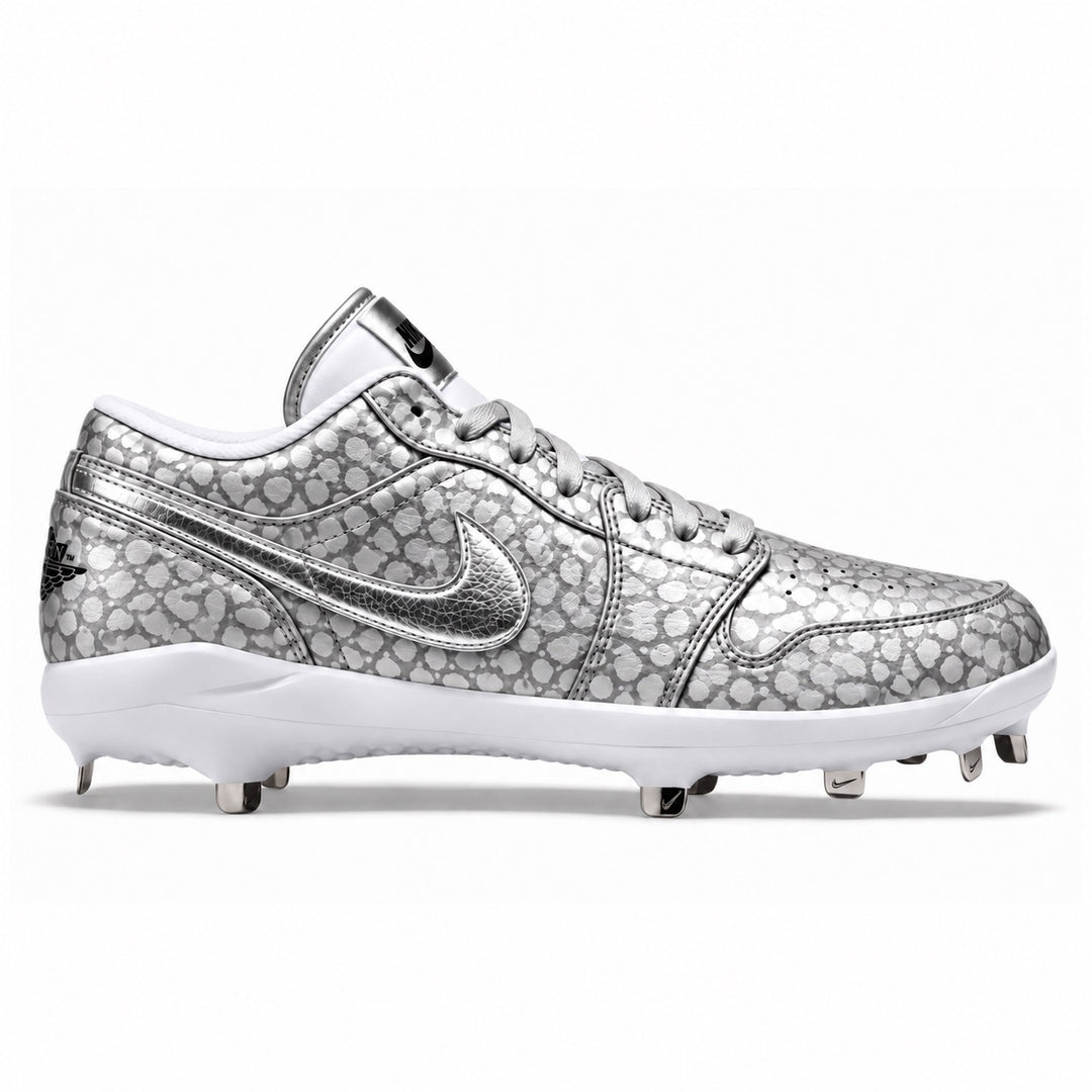 Silver and grey Jordan 1 Retro baseball cleats featuring a metallic spotted pattern, cracked silver Swoosh, matching silver laces, white midsole, and metal spikes by Stadium Custom Kicks.