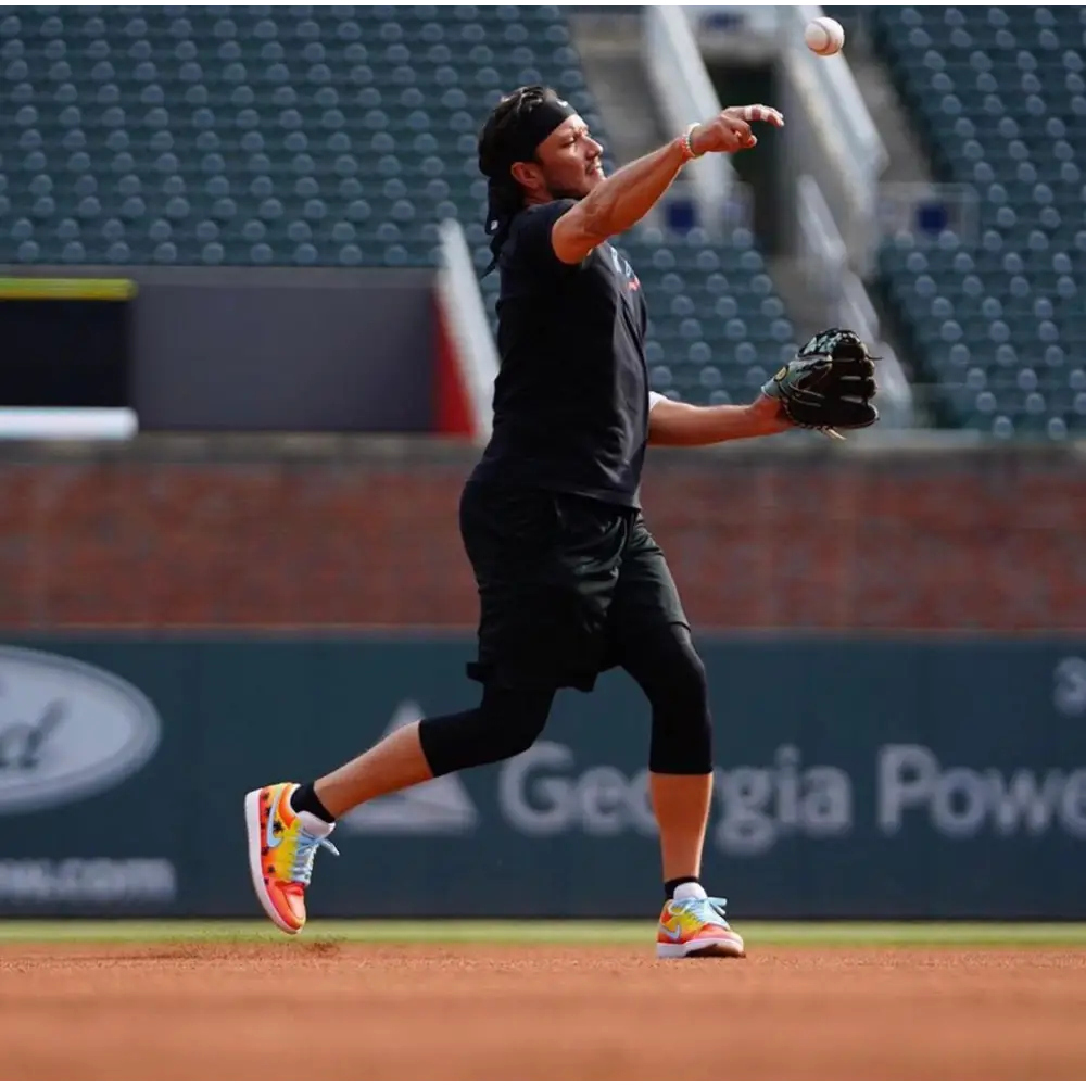 Baseball player throwing a ball wearing SoFlo Sunset Jordan 1 Low Shoes