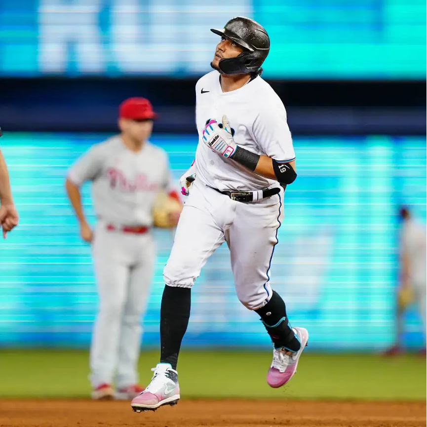 Baseball player running wearing South Beach Splatter Jordan 1 Mid Shoes