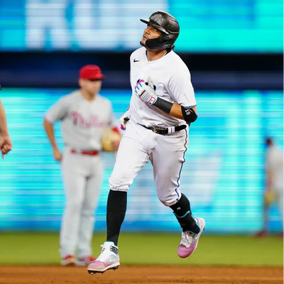 Baseball player running wearing South Beach Splatter Jordan 1 Mid Shoes