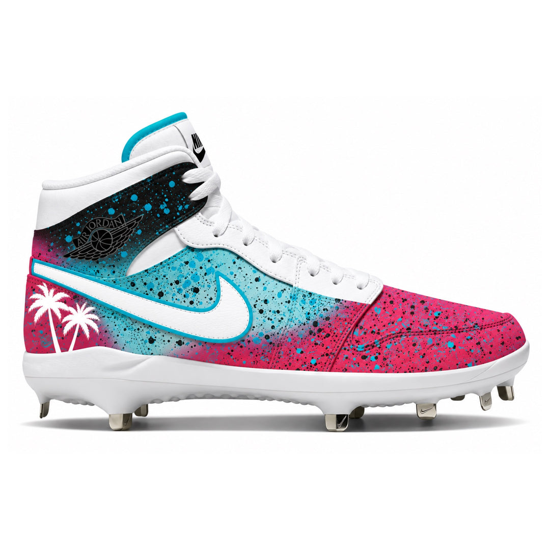 A high-top Nike baseball cleat featuring a vibrant pink and blue gradient with black paint splatters, a white Nike swoosh, a black and white Wings logo on the heel, and white palm tree graphics on a white background.