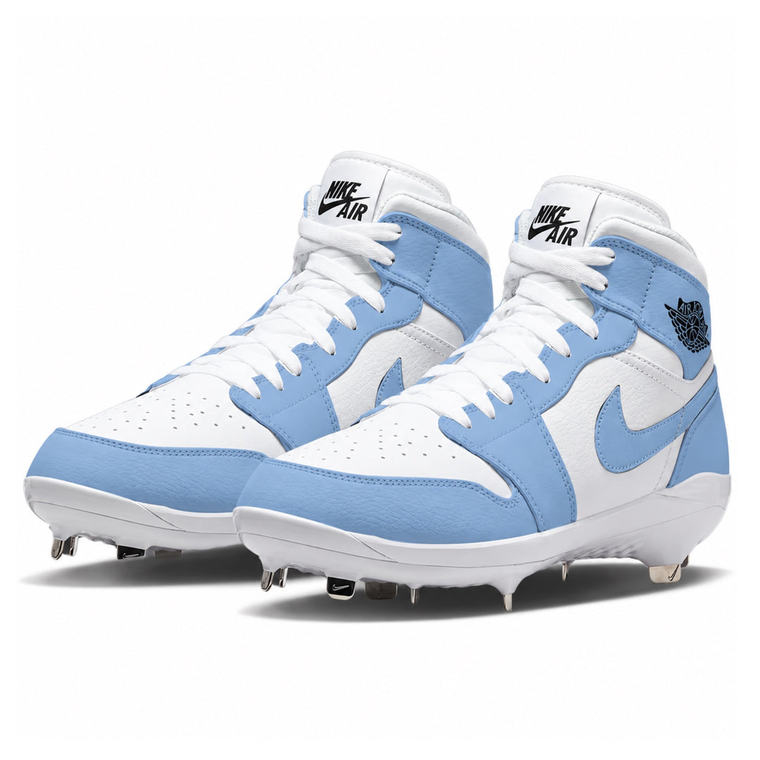 A pair of Nike high-top baseball cleats in white and light blue, featuring white laces, a white Nike Air logo on the tongue, a light blue Swoosh on the side, and black Jordan Wings branding on the ankle collar.