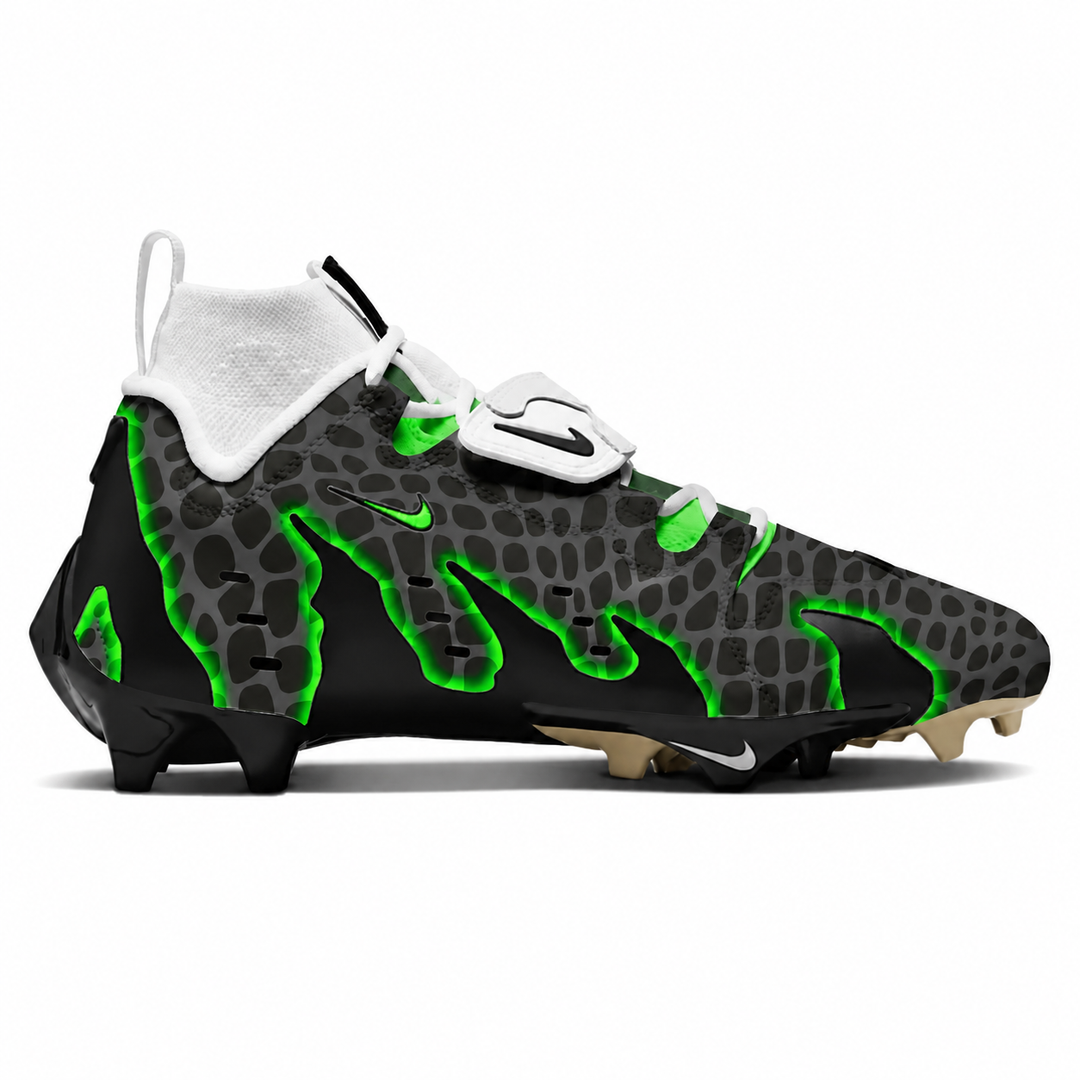 A Nike football cleat in black and gray with a bold green flame pattern, a white sock collar, and a white magnetic closure strap, shown from a side profile on a white background.